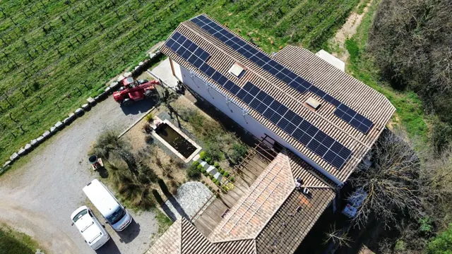 Vue drone d’une installation photovoltaïque sur bâtiment agricole entouré de vignes